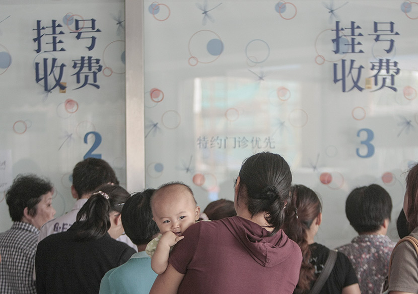 Visitors wait in line to register at a hospital in Nanjing, Jiangsu province, Aug. 4, 2009. An Xin/VCG