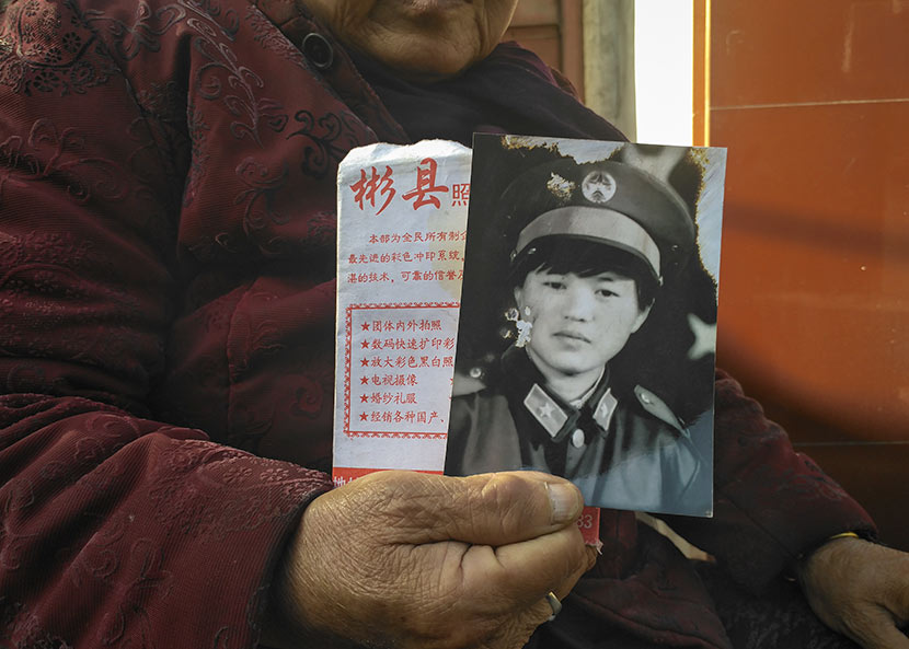 Jing Xixia’s mother holds the only portrait of her, which was taken 20 years ago, in Bin County, Shaanxi province, Nov. 7, 2017. Ming Que for Sixth Tone