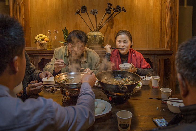 Zhou Qundan (right) eats dinner with fellow villagers in Wencun Village, Fuyang, Zhejiang province, Nov. 16, 2017. Denise Hruby/Sixth Tone