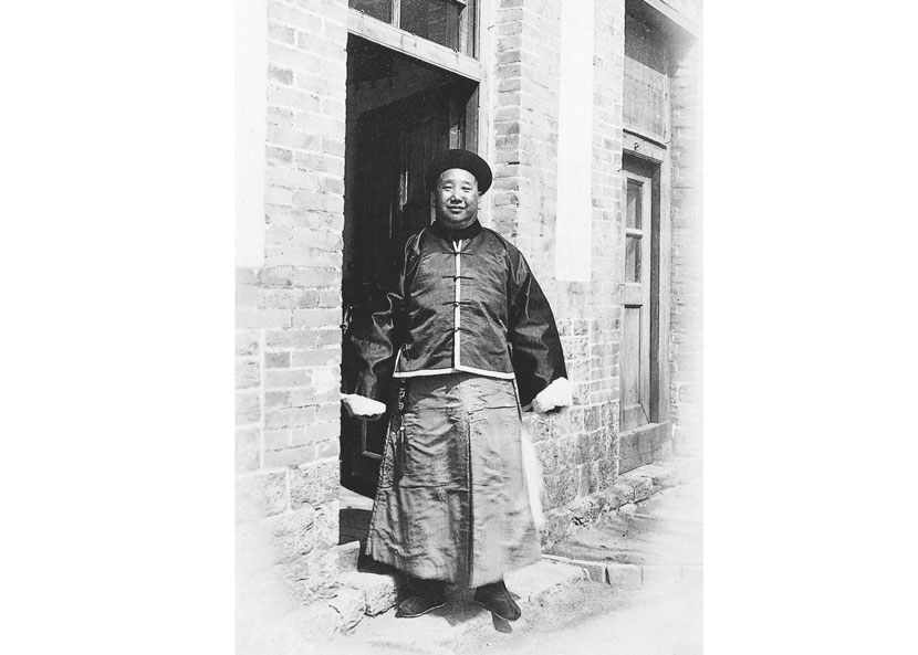 A Qing-dynasty local official dressed in his uniform poses for a photo outside a single-story house with glass-paneled windows and doors, in Yantai, Shandong province, in the early 1900s. Courtesy of ‘Old Photos’