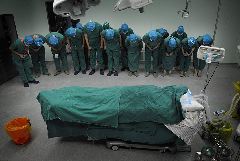 Doctors and nurses pay their respects to an organ donor after surgery to remove the patient’s usable organs at a hospital in Hefei, Anhui province, Sept. 29, 2016. VCG