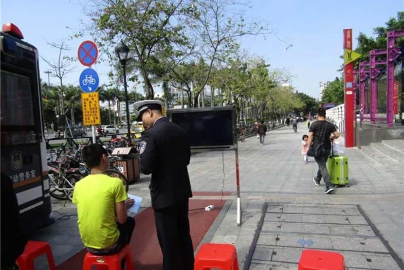 A police officer scolds a jaywalker in Guangzhou, Guangdong province, March 2018. From Weibo