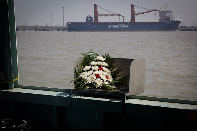 A bouquet sits on a metal chute used for scattering the deceased’s ashes during a sea burial in Shanghai, April 1, 2018. Shi Yangkun/Sixth Tone
