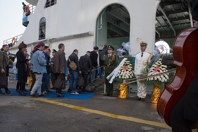 Families from Changzhou board a ferry for a mass sea burial at a dock in Shanghai, April 1, 2018. Shi Yangkun/Sixth Tone