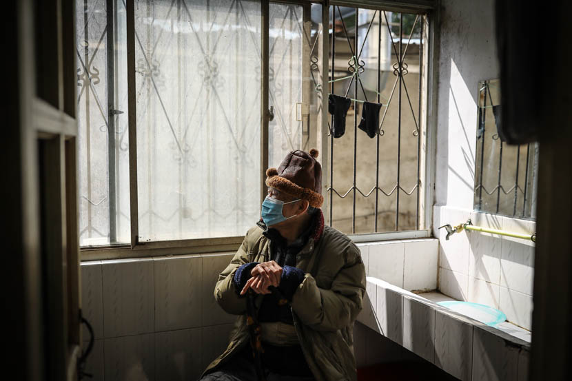 A man surnamed Li sits in his room at the quarantine center set up at the dormitories of Hubei University in Wuhan, Hubei province, March 14, 2020. Zhao Di/China Youth Daily