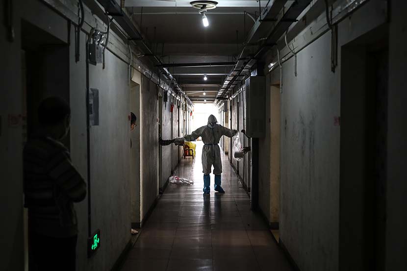 A medical worker delivers meals at the quarantine center set up in the dormitories of Hubei University in Wuhan, Hubei province, March 14, 2020. Zhao Di/China Youth Daily