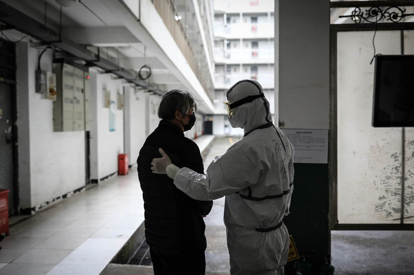 A medical worker talks with a person under observation at the quarantine center set up in the dormitories of Wuhan Vocational College of Software and Engineering in Wuhan, Hubei province, Feb. 27, 2020. Zhao Di/China Youth Daily