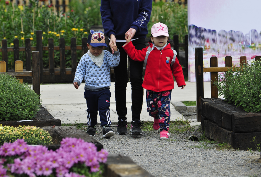 Une mère emmène ses enfants se promener dans un parc de Nanjing, province du Jiangsu, 2018. An Xin / People Visual