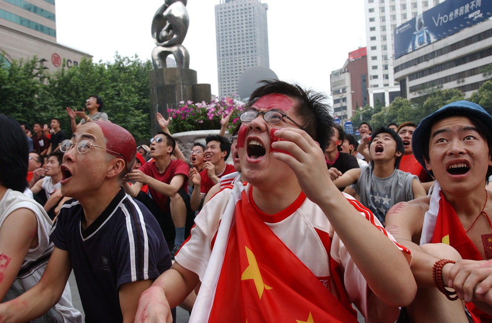 Fans watch a World Cup match in front of a large LED screen in Chengdu, Sichuan province, 2002. VCG