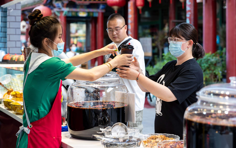 A woman sells 'suanmei tang' to tourists in Hohhot, Inner Mongolia Autonomous Region, June 18, 2022. Ding Genhou/IC