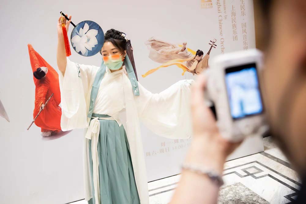 A woman wearing hanfu takes photos before the concert, Shanghai, August 19, 2022. Taken from paper