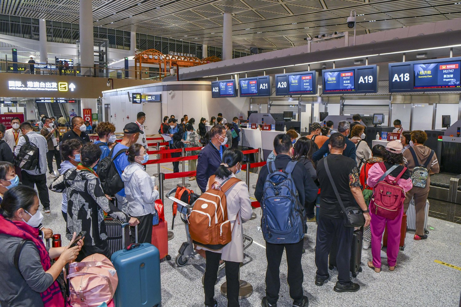 Travelers line up for their flight from Haikou to Singapore, March 15, 2023. Luo Yunfei/CNS/VCG