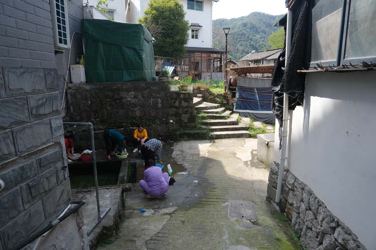 During an off-day, tea pickers wash their clothes at a communal village well.